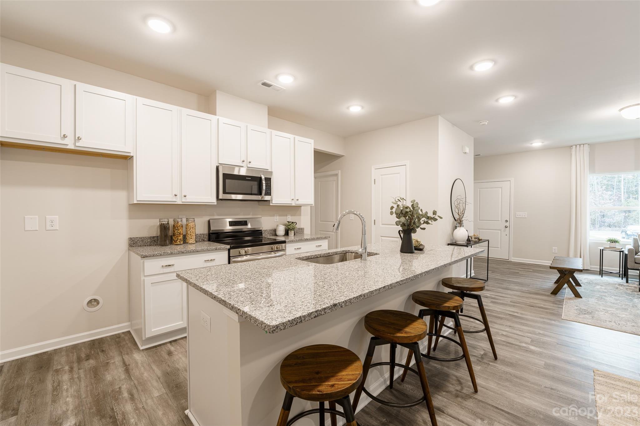 2113 Tom Sadler Road Charlotte, NC 28214 - Photo 12 of 31 a kitchen with microwave a refrigerator and chairs