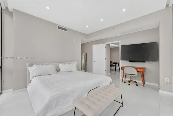 a bedroom with a bed and a flat screen tv