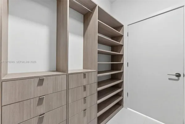 a view of walk in closet with empty racks