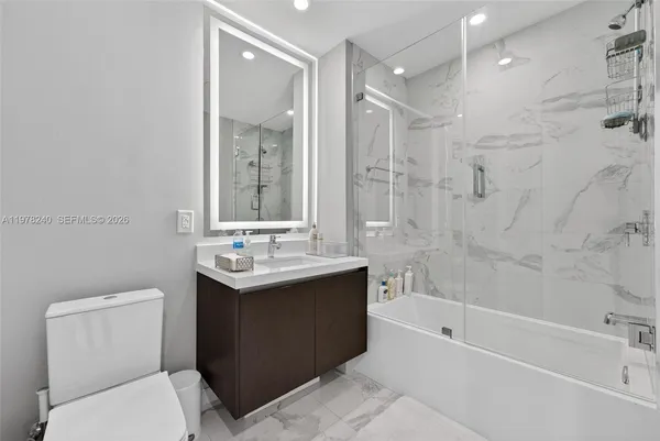 a bathroom with a sink toilet tub and shower