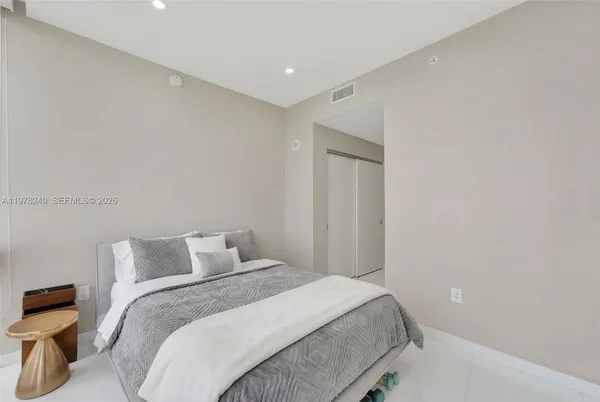 a bedroom with a bed and a night stand