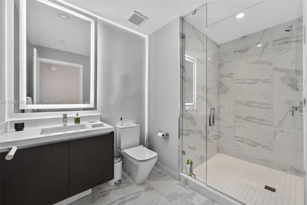 a bathroom with a bathtub shower sink mirror and toilet