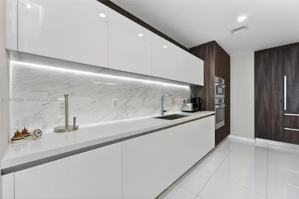 a kitchen with stainless steel appliances a sink and a refrigerator