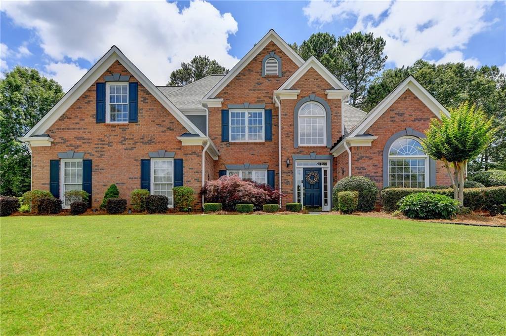 3745 Old Path Crossing Suwanee, GA 30024 - Photo 1 of 1 a front view of a house and a garden