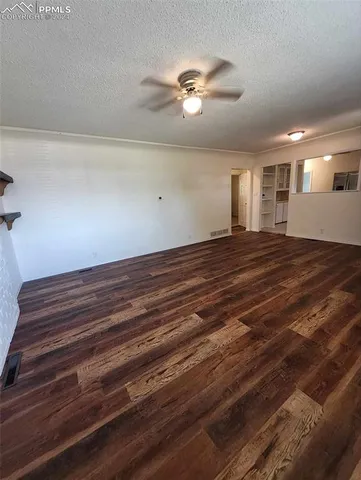 a view of empty room with window and ceiling fan