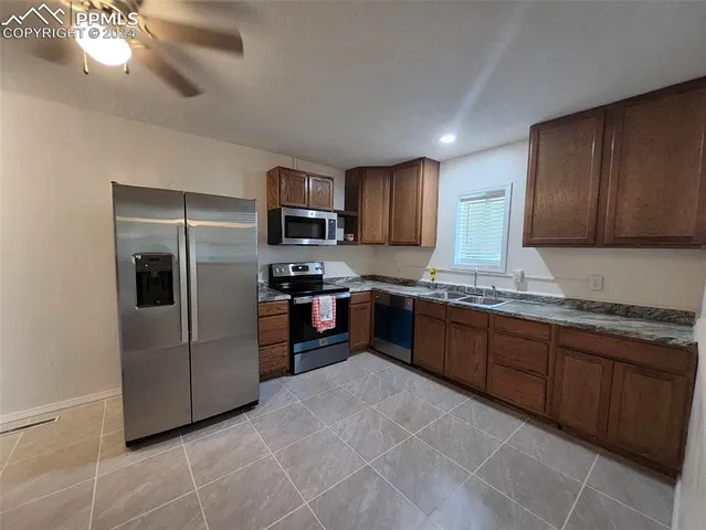 a kitchen with granite countertop a refrigerator and a sink