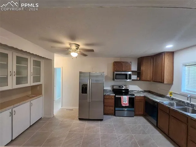 a kitchen with stainless steel appliances granite countertop a refrigerator and a stove top oven