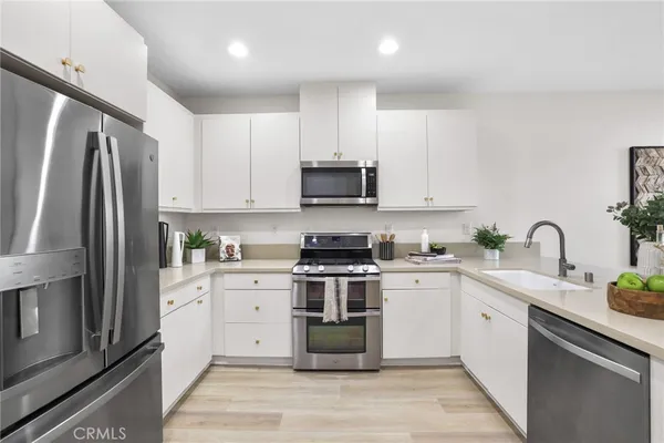 a kitchen with stainless steel appliances granite countertop a refrigerator sink and stove