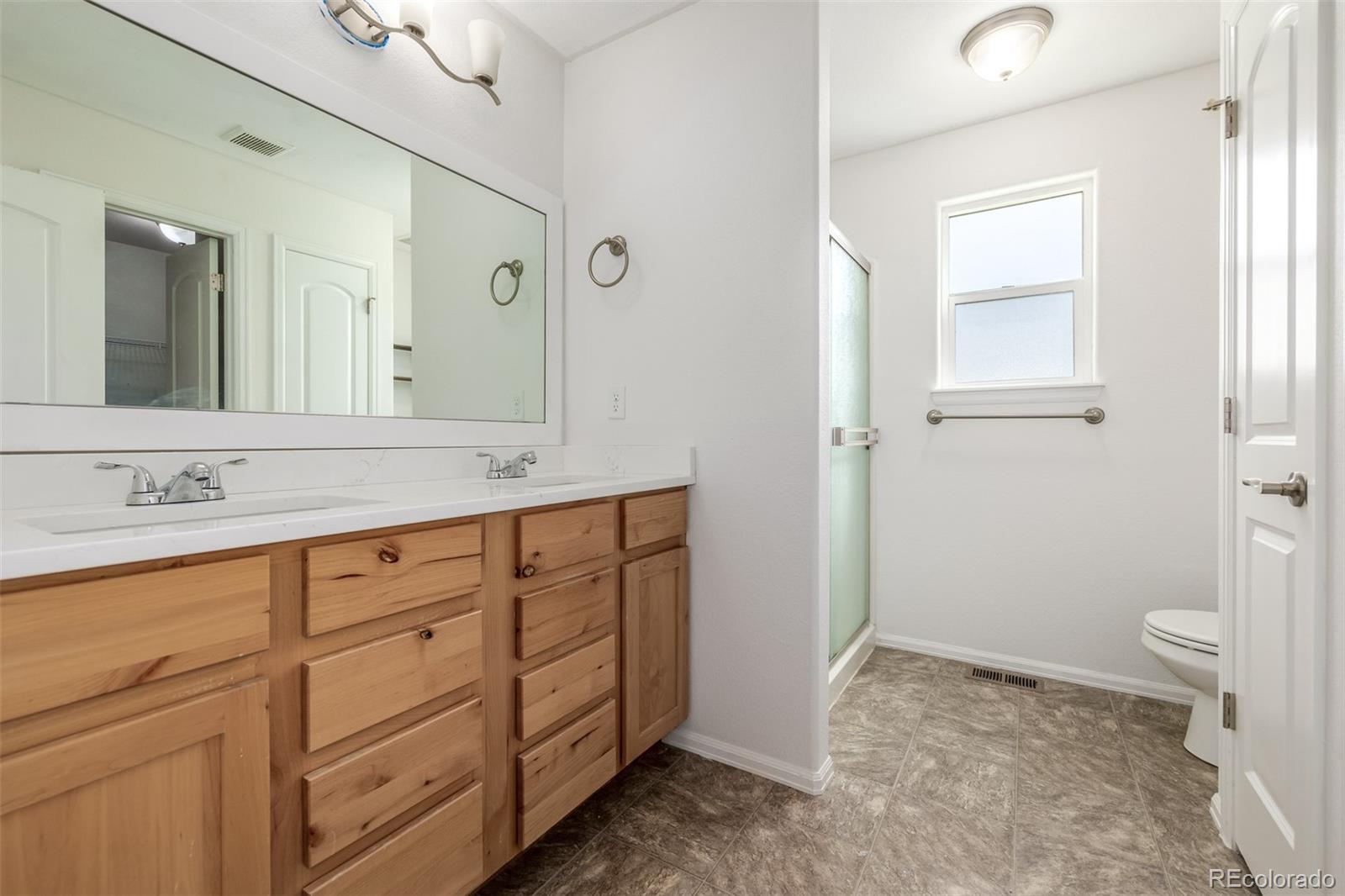 2188 Grain Bin Windsor, CO 80550 - Photo 12 of 30 a bathroom with a granite countertop sink toilet and shower