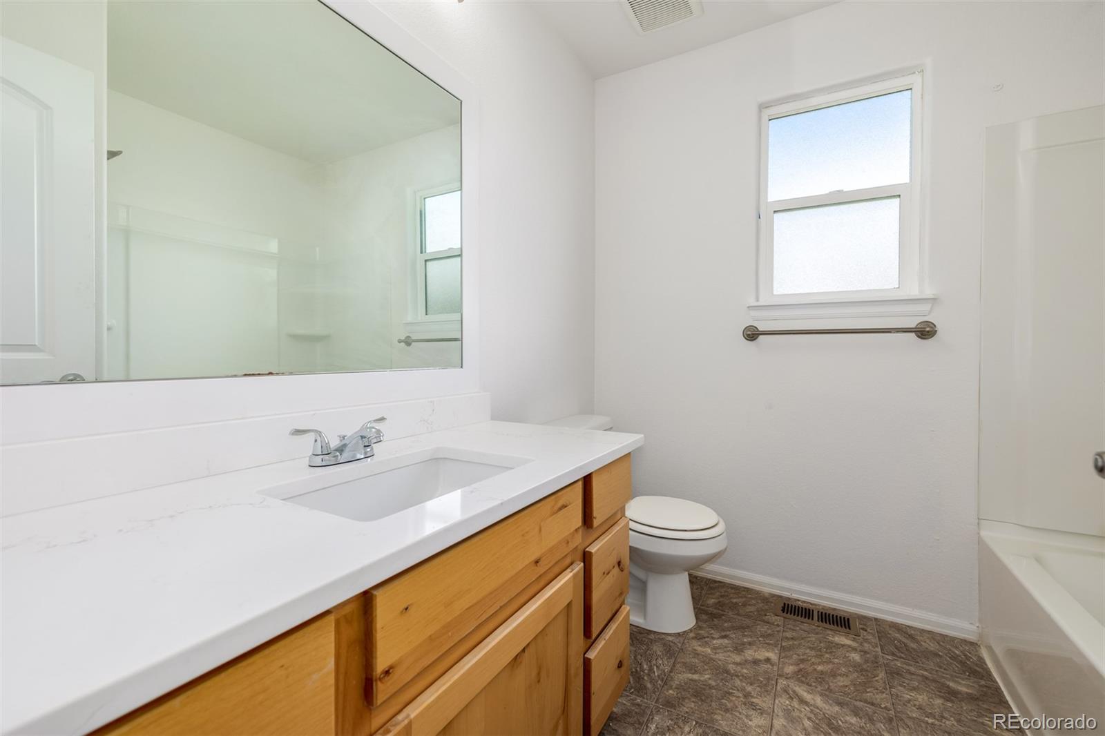 2188 Grain Bin Windsor, CO 80550 - Photo 17 of 30 a bathroom with a sink toilet and a mirror