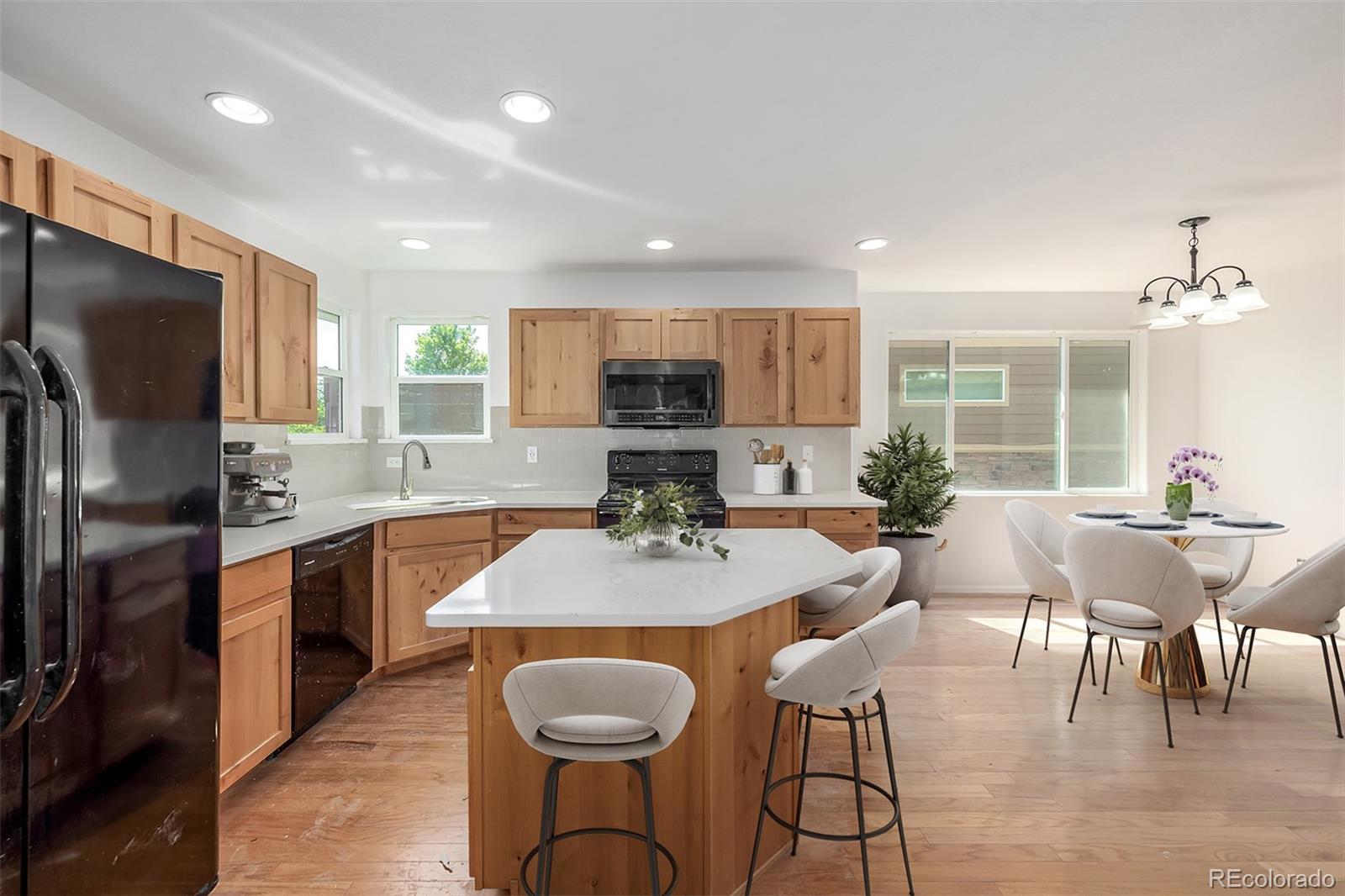 2188 Grain Bin Windsor, CO 80550 - Photo 7 of 30 a kitchen with stainless steel appliances granite countertop a kitchen island hardwood floor sink stove dining table and chairs