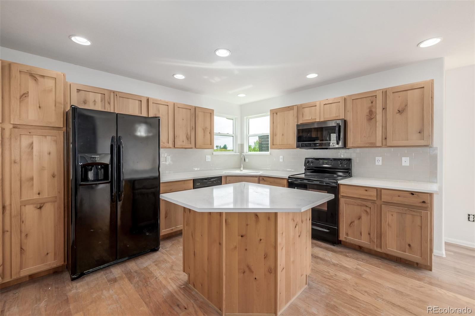 2188 Grain Bin Windsor, CO 80550 - Photo 8 of 30 a kitchen with stainless steel appliances granite countertop a refrigerator a sink a stove a microwave and island