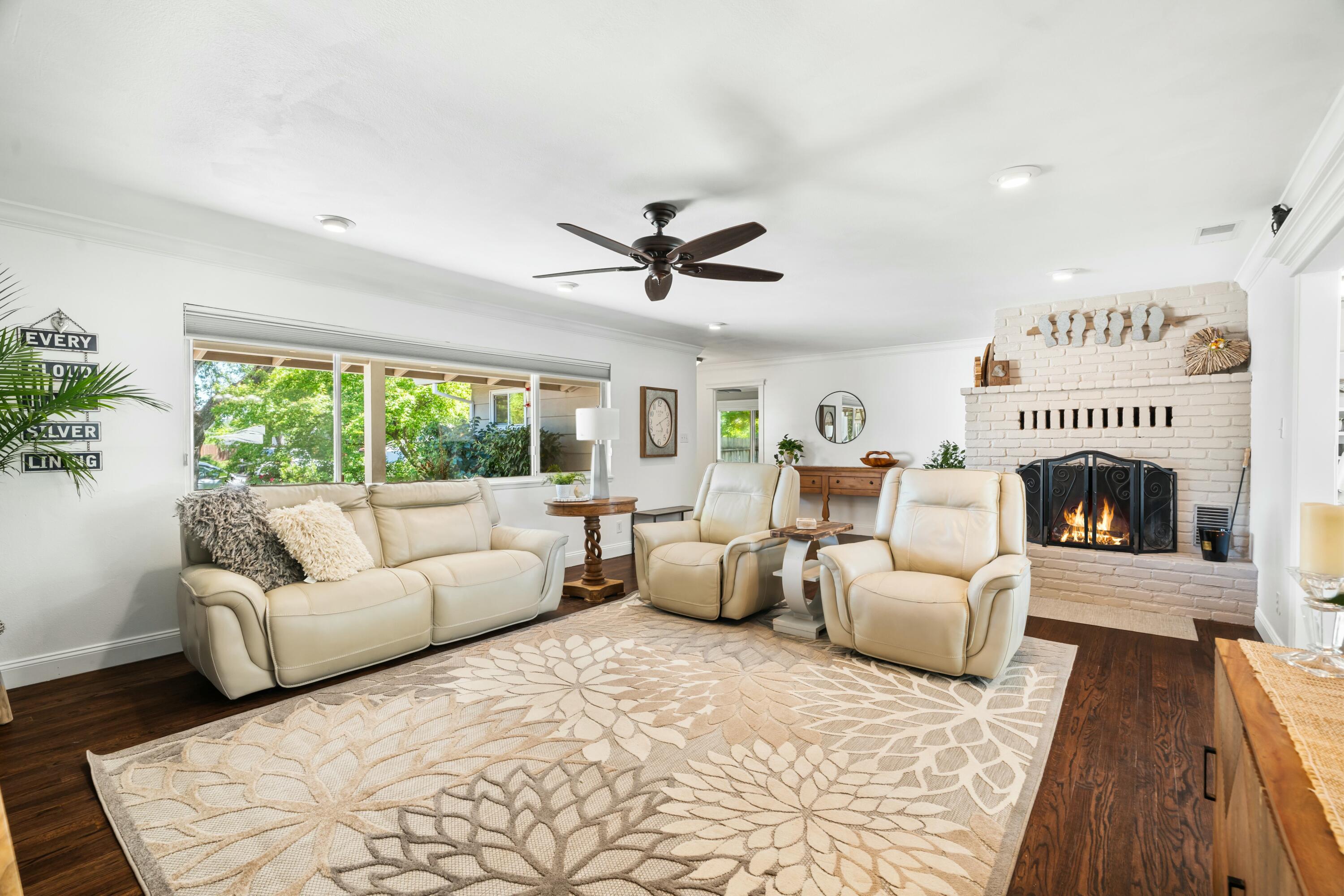 6860 Riata Drive Redding, CA 96002 - Photo 7 of 39 a living room with furniture a large window and a fireplace