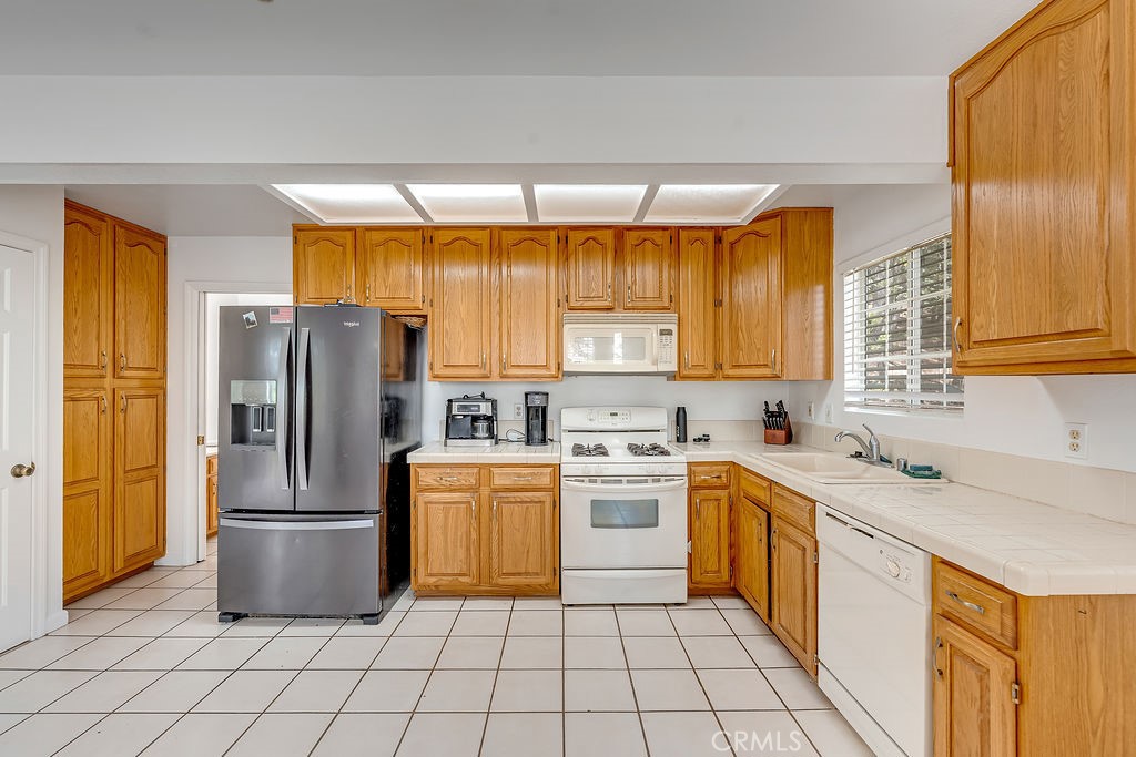 318 Old Toll Road Lake Arrowhead, CA 92352 - Photo 25 of 44 a kitchen with a sink a refrigerator and cabinets