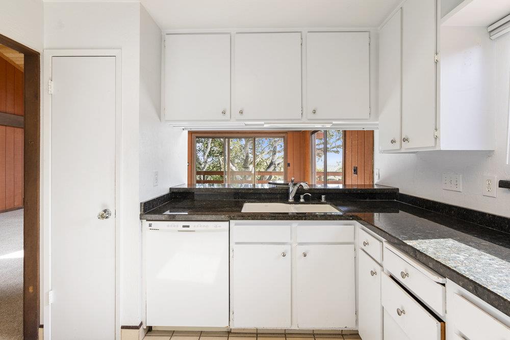 14104 Reservation Road Salinas, CA 93908 - Photo 21 of 56 a kitchen with granite countertop a sink and white cabinets