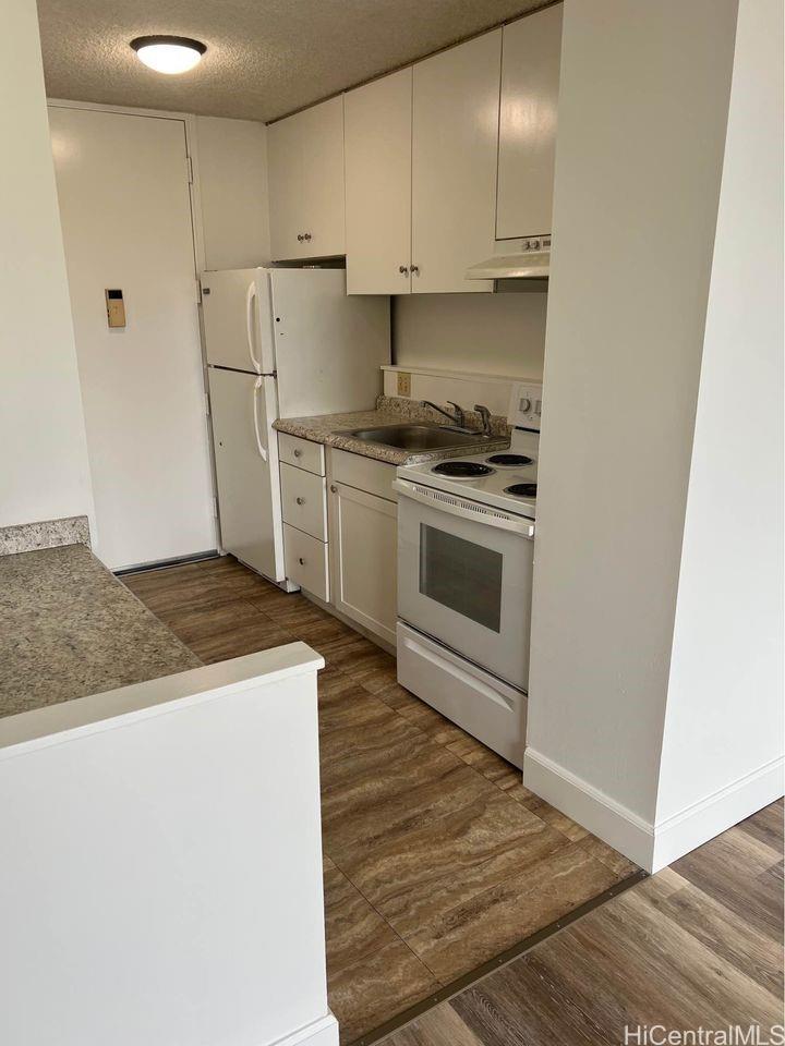 1112 Kinau Street, Unit 506 Honolulu, HI 96814 - Photo 5 of 12 a kitchen with granite countertop a sink stove and refrigerator