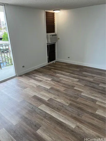 en empty room with wooden floor and fan