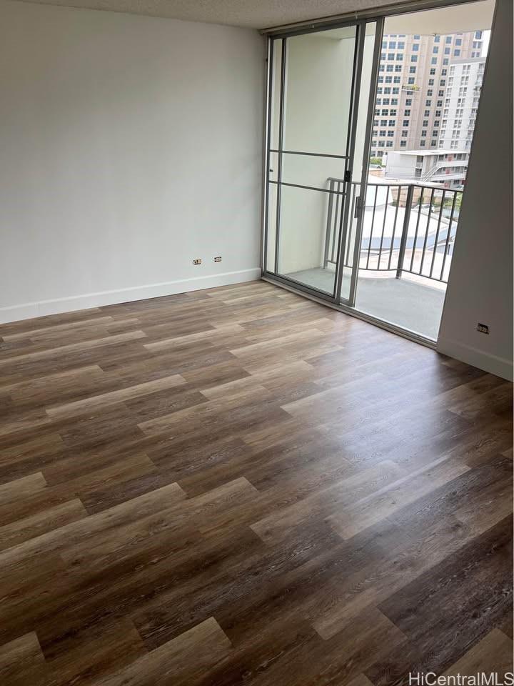 1112 Kinau Street, Unit 506 Honolulu, HI 96814 - Photo 7 of 12 en empty room with wooden floor and fan