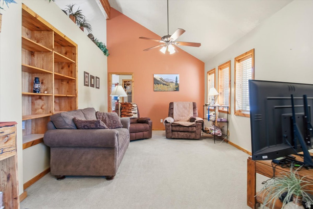 811 East Canyon Road Mayfield, UT 84643 - Photo 17 of 57 Spacious living area featuring a vaulted ceiling with exposed wood beams, a ceiling fan, and light beige carpeting