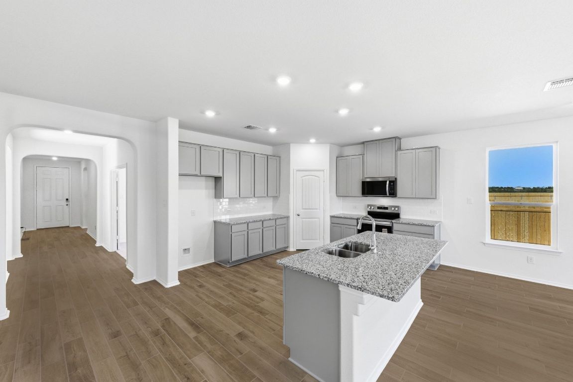 Undisclosed Address Manor, TX 78653 - Photo 12 of 31 a kitchen with stainless steel appliances granite countertop a sink stove and refrigerator