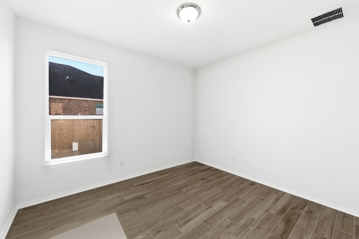 Undisclosed Address Manor, TX 78653 - Photo 17 of 31 a view of an empty room with wooden floor and a window