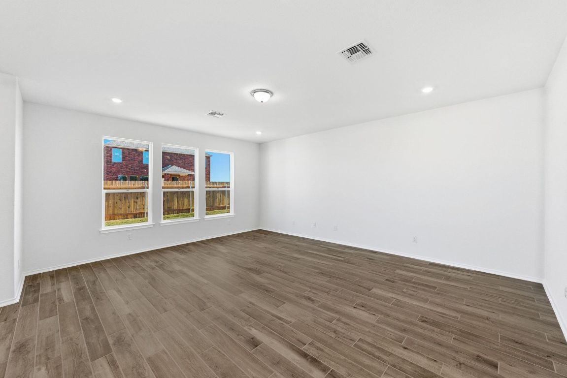 Undisclosed Address Manor, TX 78653 - Photo 7 of 31 a view of an empty room with wooden floor and windows