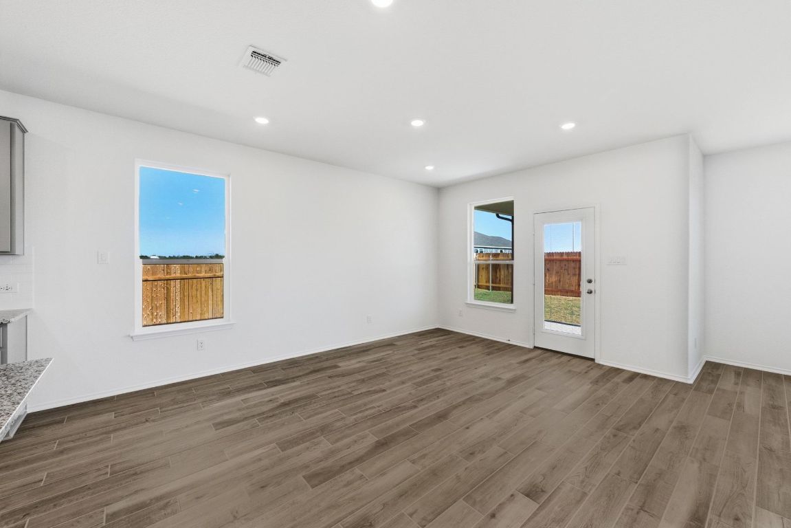 Undisclosed Address Manor, TX 78653 - Photo 8 of 31 a view of an empty room with wooden floor and a window