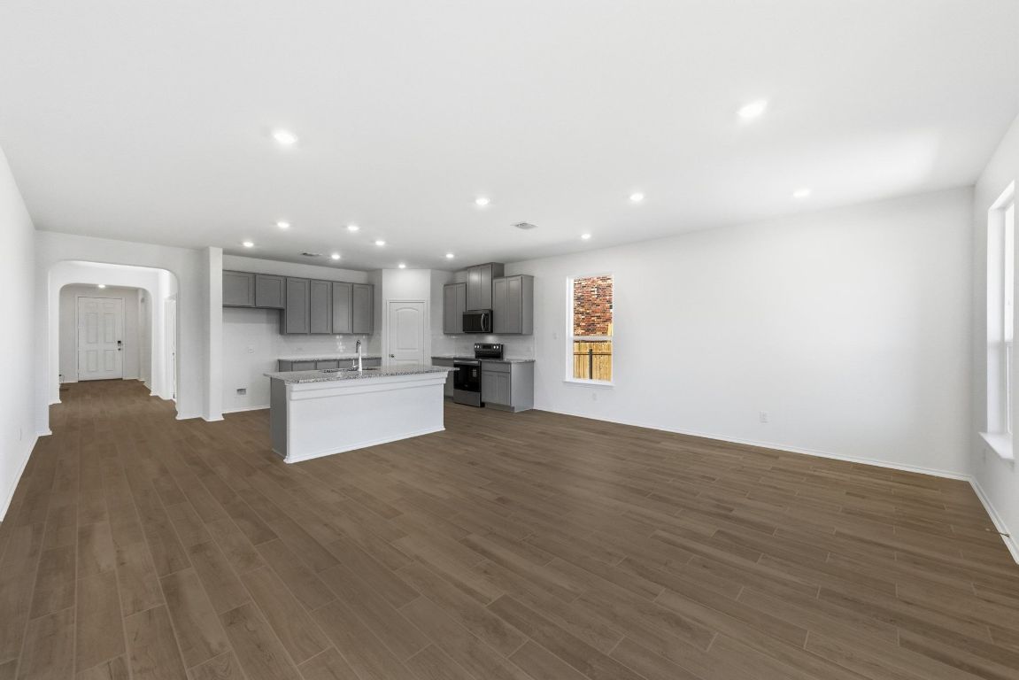 Undisclosed Address Manor, TX 78653 - Photo 9 of 31 a view of kitchen with kitchen island a sink wooden floor and a stove top oven