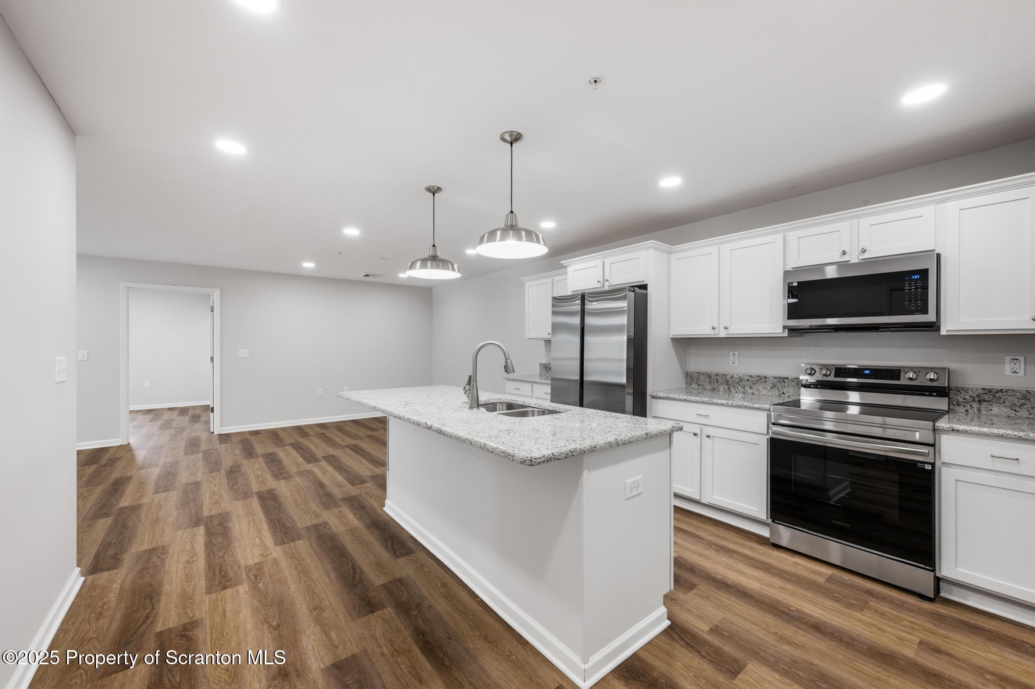 45 Zackery Way Old Forge, PA 18518 - Photo 8 of 26 a kitchen with stainless steel appliances granite countertop a sink dishwasher a stove and a refrigerator with wooden floor