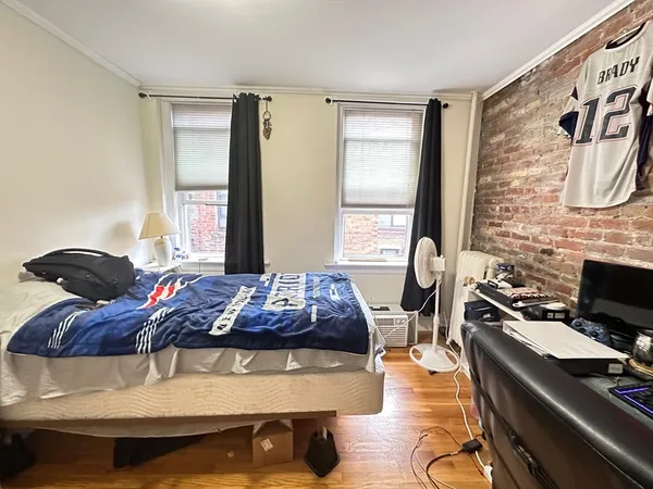 a bedroom with a bed and wooden floor