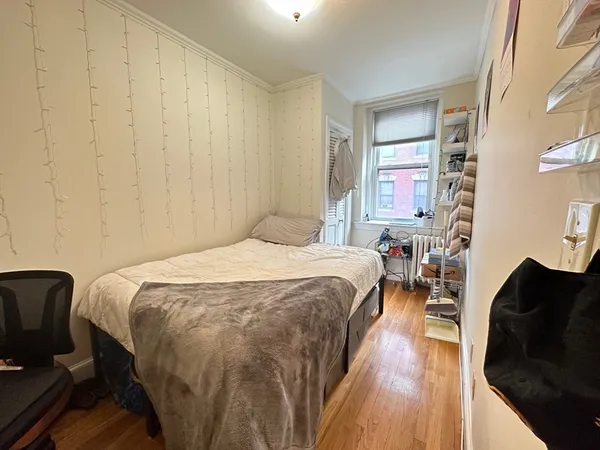 a bedroom with a bed window and a chair