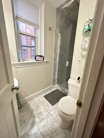 a white toilet sitting next to a bathroom sink and a tub