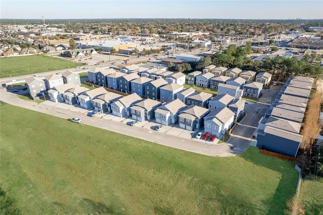 an aerial view of residential houses with outdoor space and trees