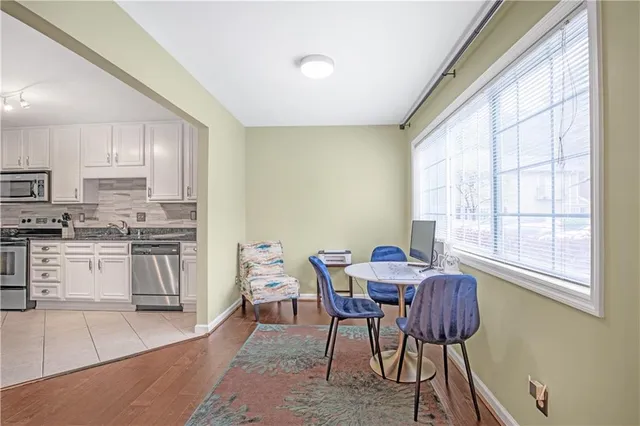 a kitchen with stainless steel appliances granite countertop a stove a sink a microwave and a dining table