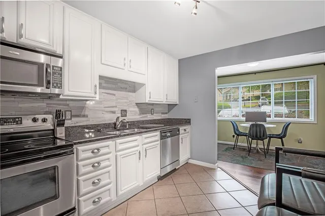 a kitchen with appliances a sink and cabinets