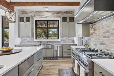 a kitchen with stainless steel appliances granite countertop a sink stove and refrigerator
