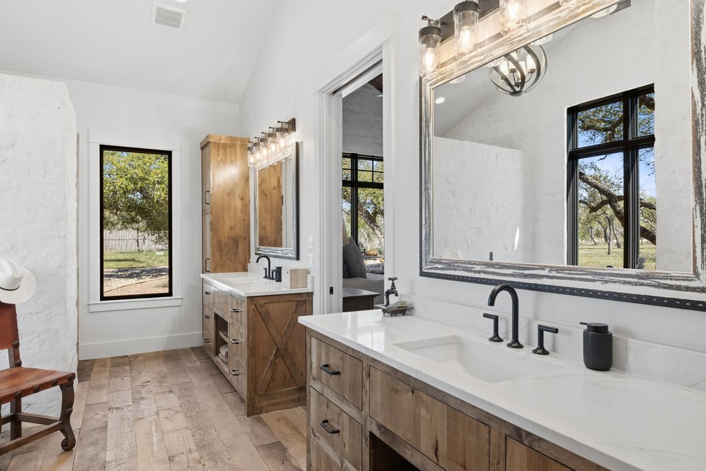 1660 Windmill Run Wimberley, TX 78676 - Photo 16 of 40 a bathroom with double vanity and a mirror