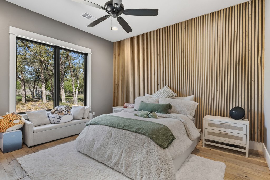 1660 Windmill Run Wimberley, TX 78676 - Photo 19 of 40 a bedroom with a large bed couch and a window