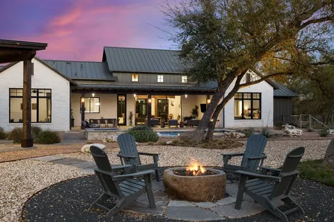 a swimming pool with outdoor seating and yard in back