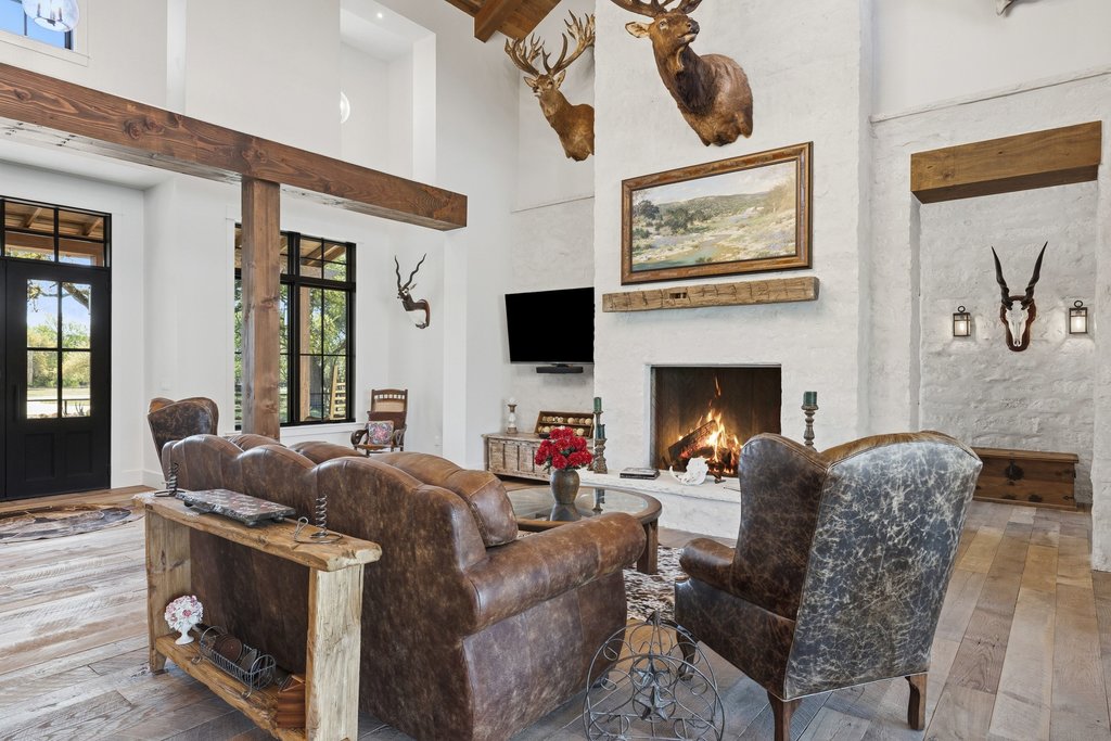 1660 Windmill Run Wimberley, TX 78676 - Photo 7 of 40 a living room with furniture a flat screen tv and a fireplace