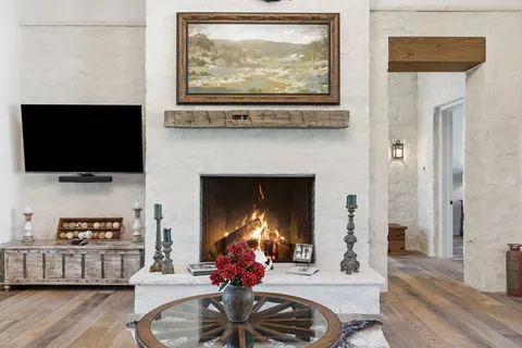 a living room with furniture a flat screen tv and a fireplace