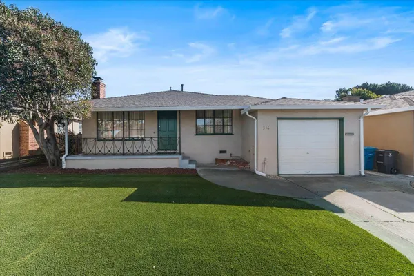a front view of a house with a garden and yard