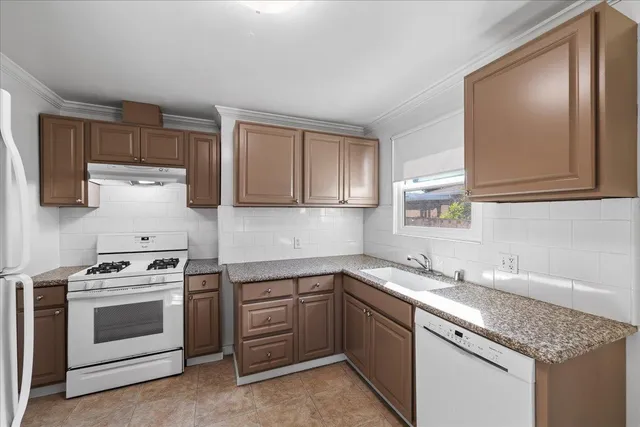 a kitchen with a stove sink and cabinets
