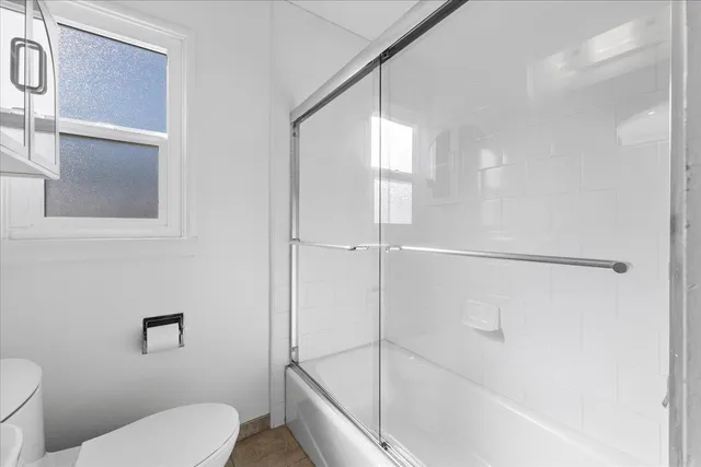 a bathroom with a toilet and a shower