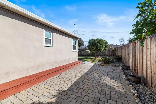 a view of backyard with potted plants and wooden fence