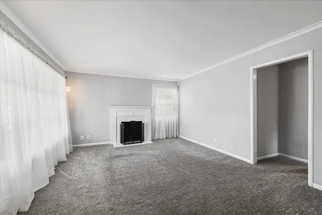 a view of an empty room with a fireplace and a window
