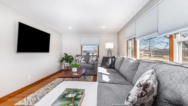 a living room with furniture a flat screen tv and a floor to ceiling window