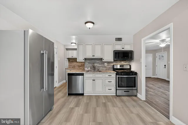 a kitchen with granite countertop a refrigerator stove and oven