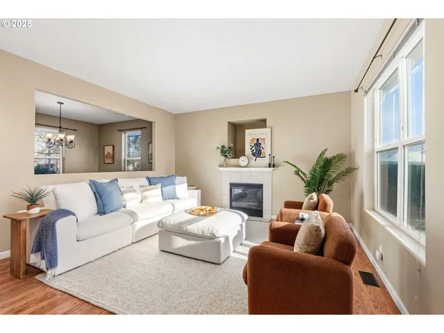 a living room with furniture a fireplace a potted plant and a window