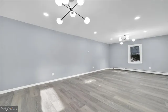a large kitchen with cabinets wooden floor and stainless steel appliances